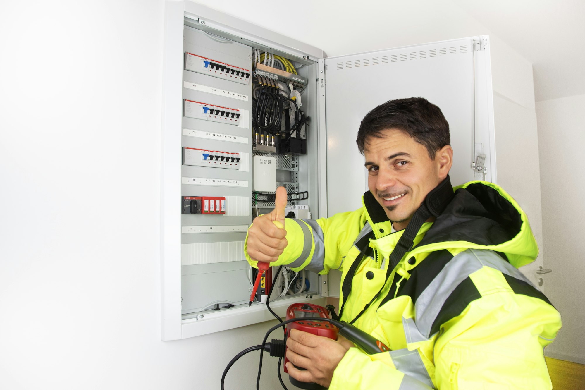 Electrician in hi-vis working on a distribution board
